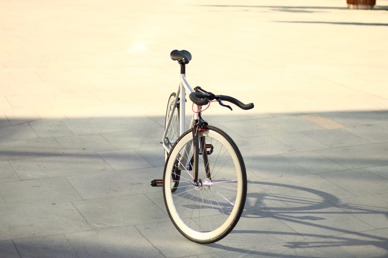 A stylish fixed gear bicycle placed on a bright urban street, perfect for outdoor enthusiasts.